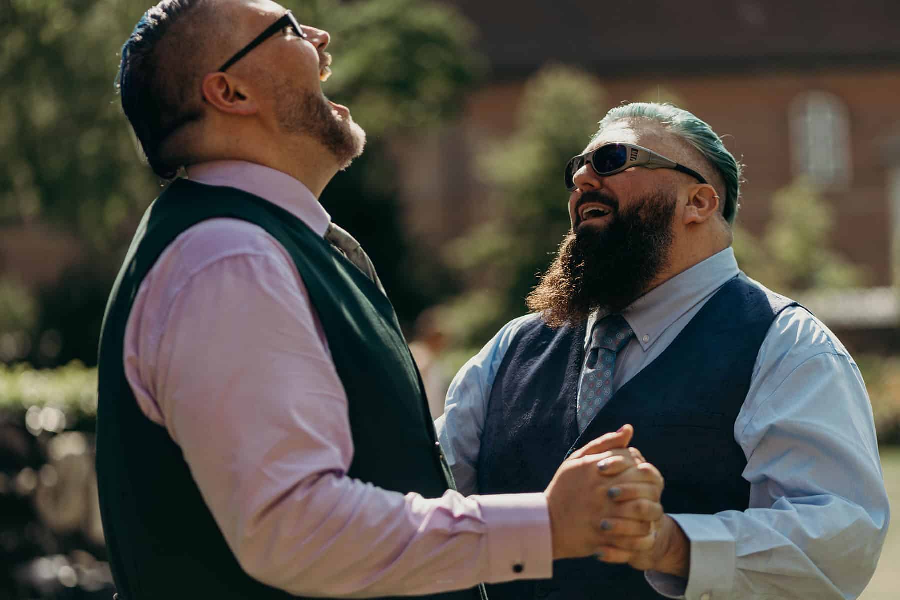 Two gay adult men dancing in glee
